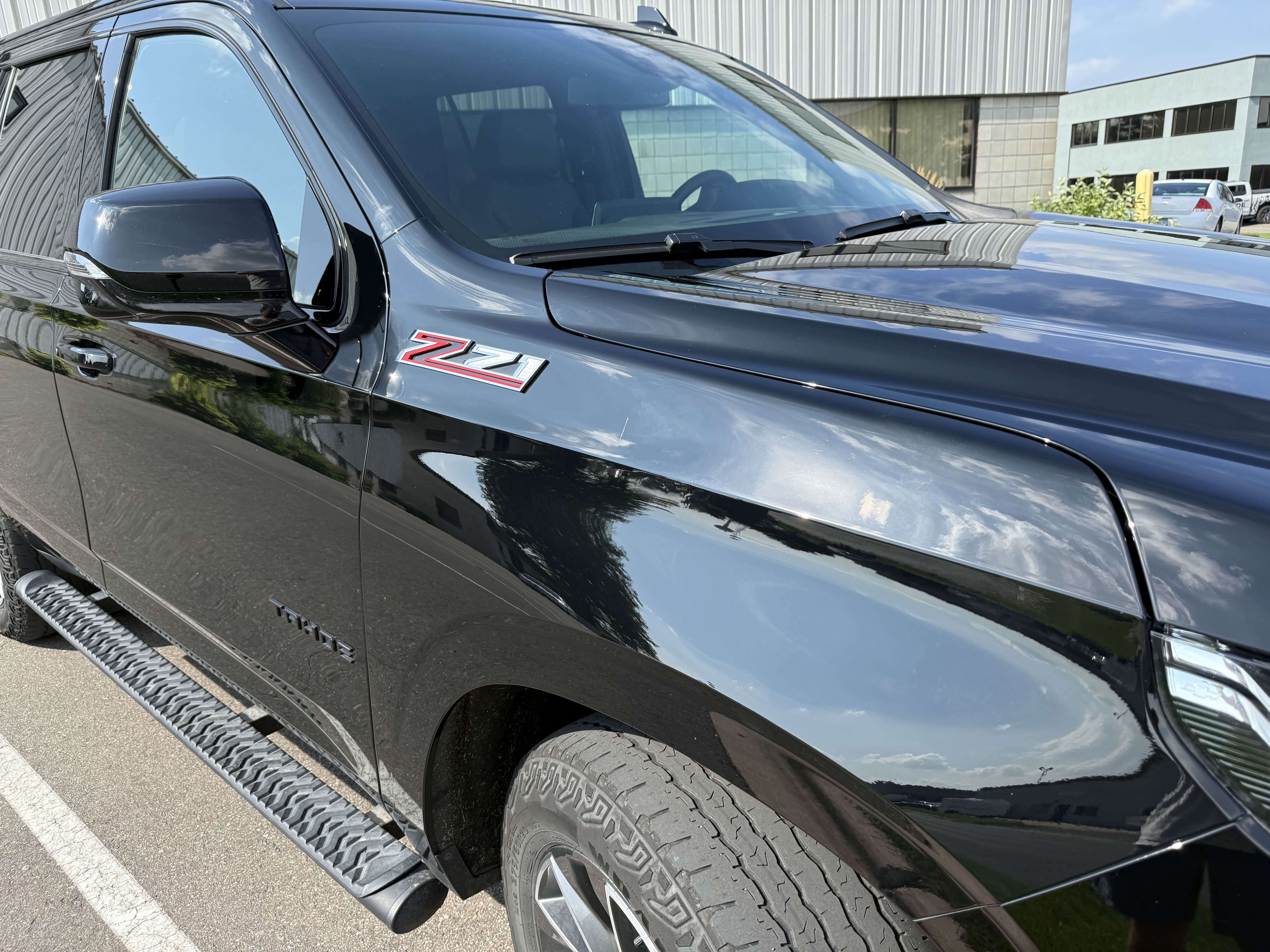 Black Chevrolet Tahoe fender after dent repair, smooth and reflective