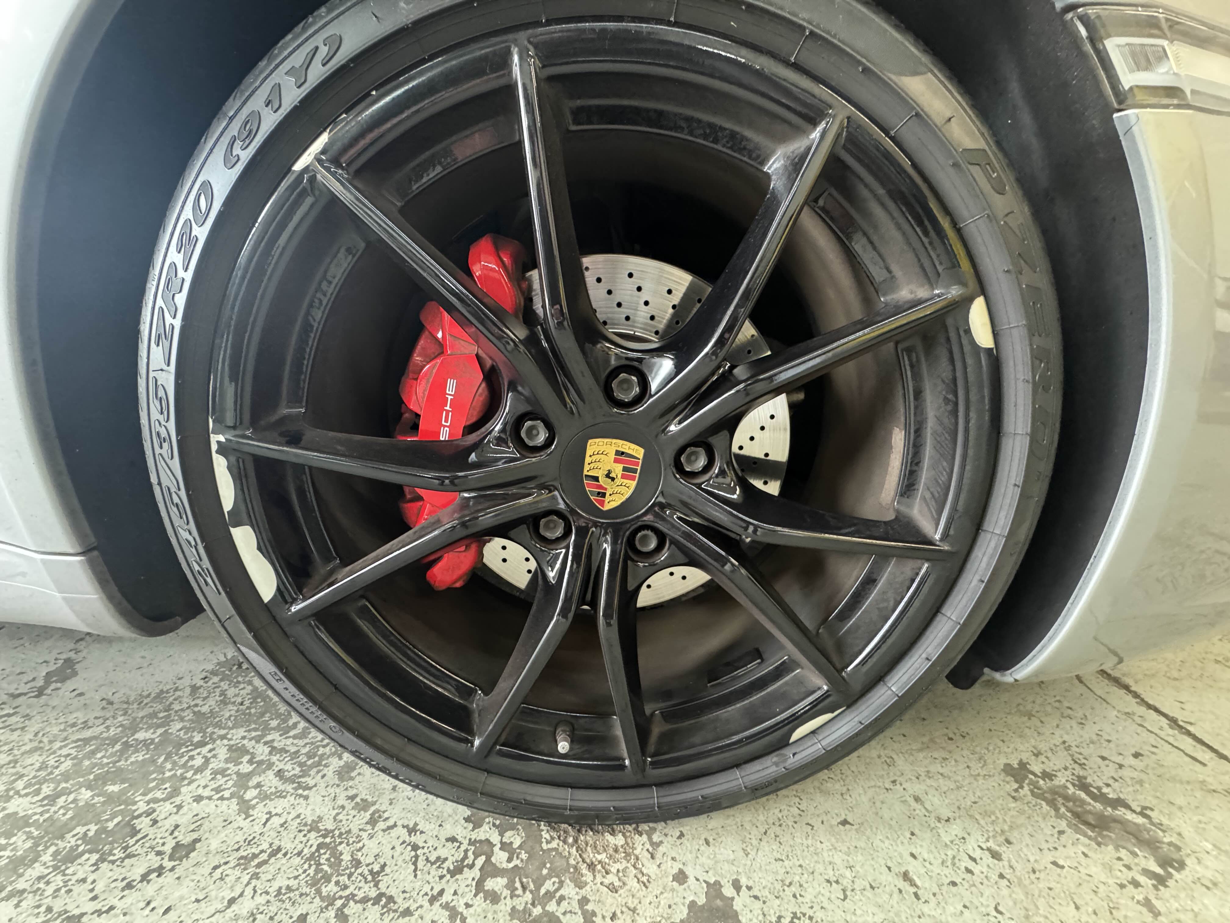 Damaged black car wheel rim with curb rash before repair
