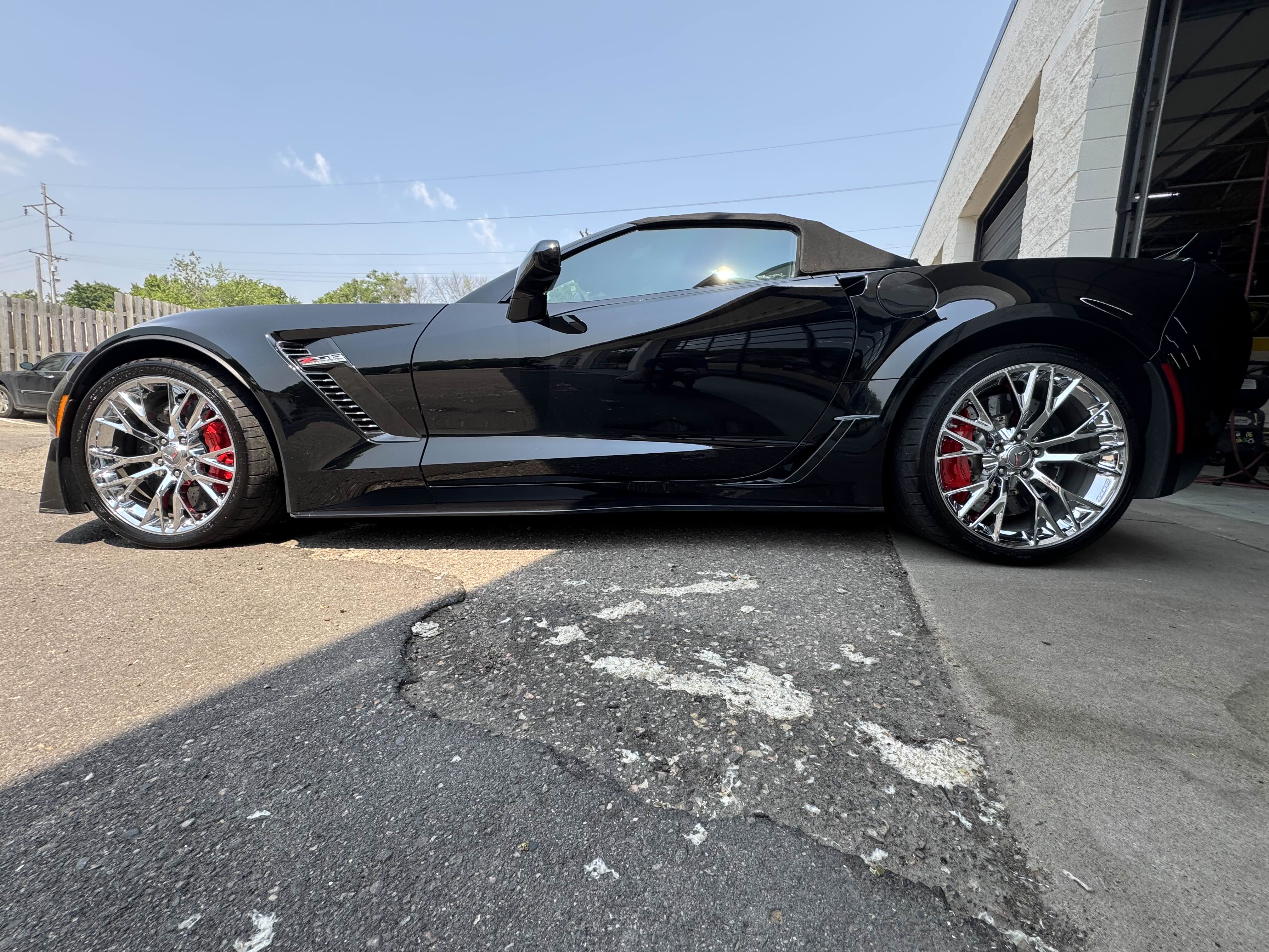 Side view of black Corvette with shiny wheels